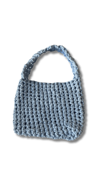 a blue crocheted bag on a black background