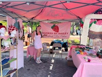 a woman standing in front of a pink tent