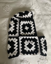 a black and white crocheted blanket on a bed