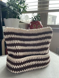 a brown and white crocheted bag sitting on top of a table