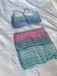 two crocheted bikinis on a bed