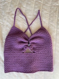 a purple crocheted top on a bed