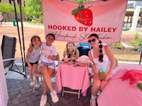 a group of girls sitting at a table with a sign that says hooked by haley